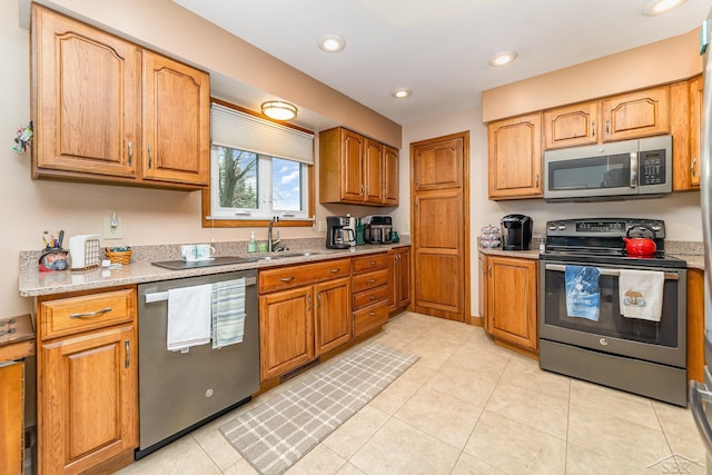 2615 Yosemite St, Saginaw, MI 48603 - kitchen featuring stainless steel appliances, a sink, recessed lighting, light tile patterned floors, and brown cabinetry