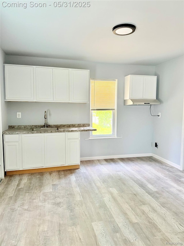 3648 Mack Ave, Hamtramck, MI 48207 - kitchen featuring a sink, white cabinetry, light wood-style flooring, and baseboards
