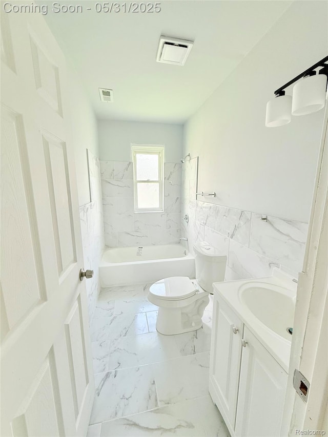 3648 Mack Ave, Hamtramck, MI 48207 - bathroom with toilet, vanity, marble look tiles, a wainscoted wall, and shower / bath combination