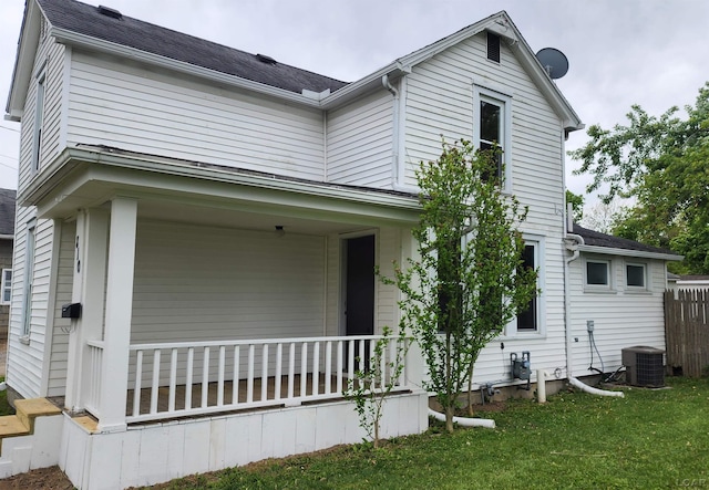 810 Division St, Adrian, MI 49221 - view of home's exterior with covered porch, cooling unit, a yard, and roof with shingles