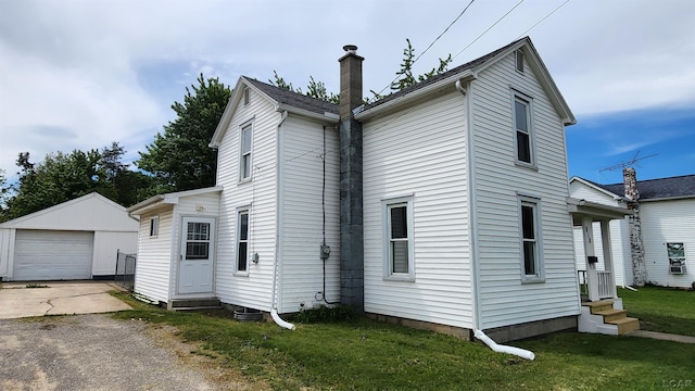 810 Division St, Adrian, MI 49221 - view of home's exterior with entry steps, an outdoor structure, a chimney, a yard, and a garage