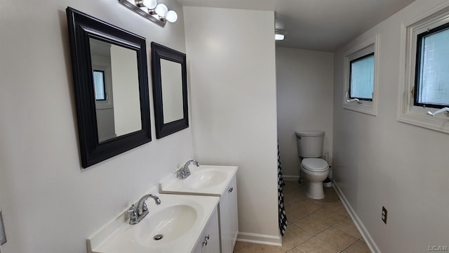 810 Division St, Adrian, MI 49221 - bathroom with tile patterned floors, toilet, double vanity, and baseboards