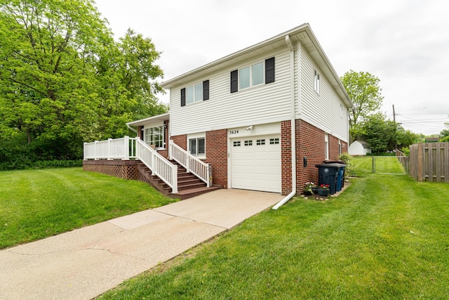 3624 Terhune Rd, Ann Arbor, MI 48104 - split level home featuring brick siding, a garage, concrete driveway, a wooden deck, and stairs