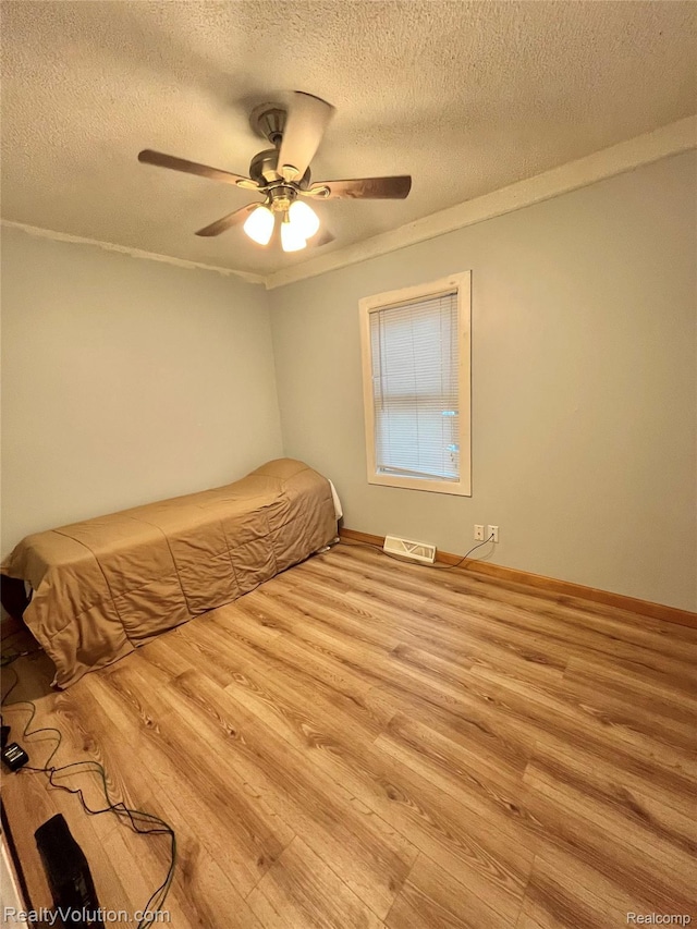 25850 Eureka Dr, Warren, MI 48091 - bedroom with wood finished floors, a textured ceiling, ceiling fan, crown molding, and baseboards