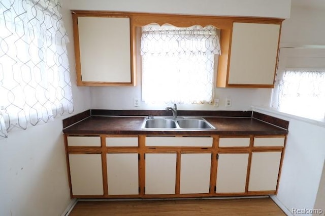 2910 Meisner Ave, Flint, MI 48506 - kitchen with a sink, dark countertops, and wood finished floors