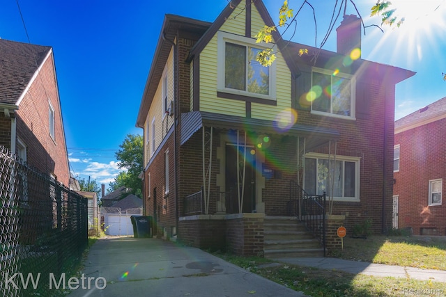 17344 Greenlawn St, Detroit, MI 48221 - view of front facade featuring brick siding, a chimney, driveway, and a porch