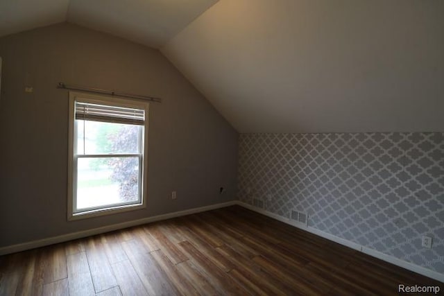 111 N Genesee St, Davison, MI 48423 - additional living space featuring dark wood-style floors, baseboards, lofted ceiling, and wallpapered walls