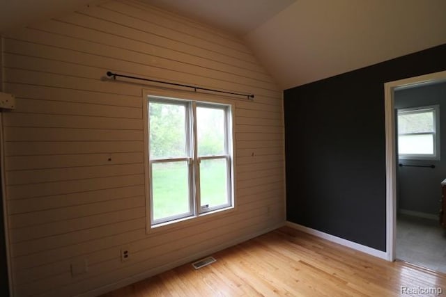 111 N Genesee St, Davison, MI 48423 - unfurnished room featuring wooden walls, lofted ceiling, light wood-style floors, and baseboards