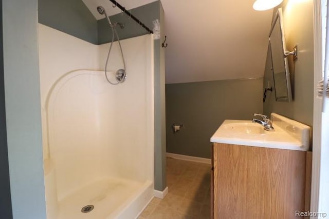 111 N Genesee St, Davison, MI 48423 - bathroom featuring a shower, vanity, lofted ceiling, baseboards, and tile patterned flooring