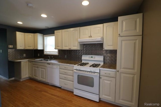 111 N Genesee St, Davison, MI 48423 - kitchen featuring white appliances, under cabinet range hood, a sink, white cabinets, and tasteful backsplash