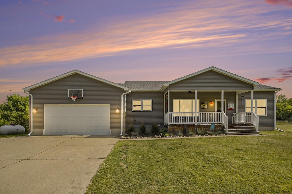 8862 Bever Rd, Delton, MI 49046 - ranch-style house with covered porch, a front yard, driveway, and a garage