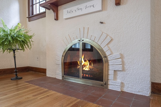 2323 Paris Ave SE, Grand Rapids, MI 49507 - detailed view of a textured wall, wood finished floors, and a glass covered fireplace