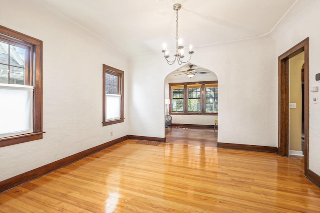 2323 Paris Ave SE, Grand Rapids, MI 49507 - unfurnished room with arched walkways, a chandelier, light wood-style flooring, and baseboards