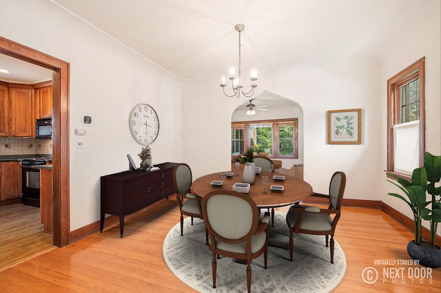 2323 Paris Ave SE, Grand Rapids, MI 49507 - dining area with a chandelier, light wood-type flooring, baseboards, and arched walkways
