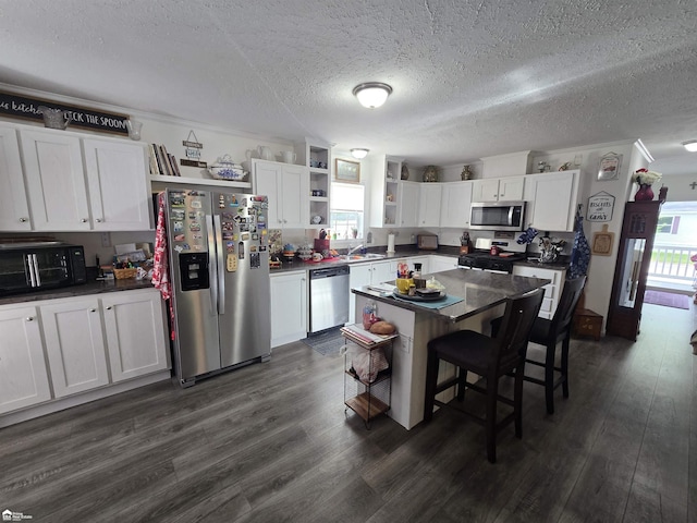 4101 S Sheridan Rd, Lennon, MI 48449 - kitchen featuring open shelves, appliances with stainless steel finishes, dark countertops, plenty of natural light, and a textured ceiling
