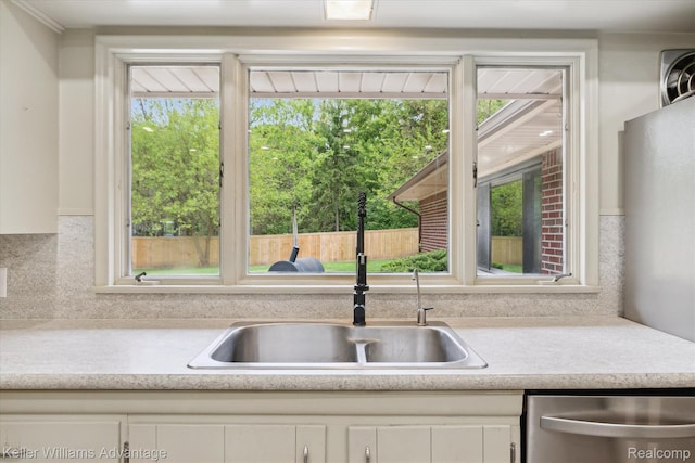 58540 Grand River Ave, New Hudson, MI 48165 - kitchen with a sink, appliances with stainless steel finishes, light countertops, white cabinetry, and backsplash