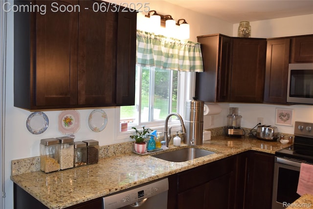 7448 Miller Rd, Swartz Creek, MI 48473 - kitchen featuring appliances with stainless steel finishes, a sink, dark brown cabinets, and light stone counters