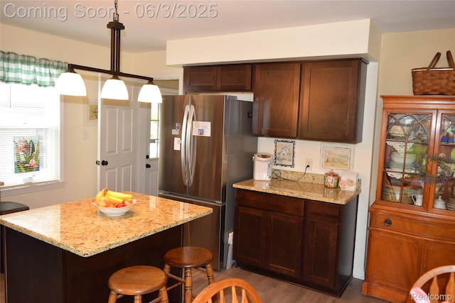 7448 Miller Rd, Swartz Creek, MI 48473 - kitchen with freestanding refrigerator, healthy amount of natural light, light stone countertops, and light wood finished floors