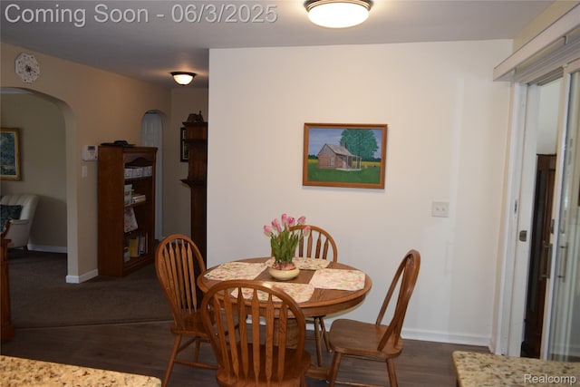 7448 Miller Rd, Swartz Creek, MI 48473 - dining space with arched walkways, dark wood-style flooring, and baseboards
