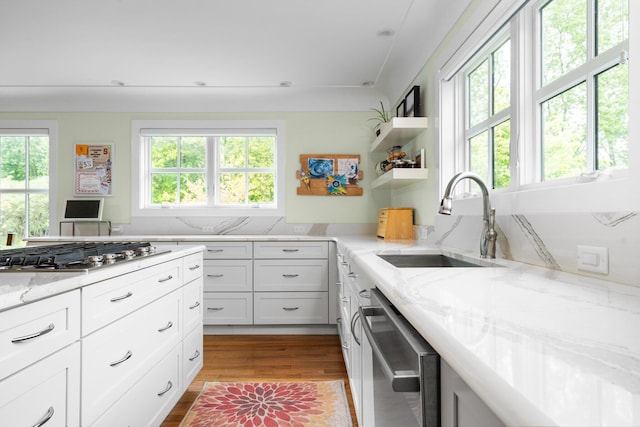 2928 Heeney Rd, Stockbridge, MI 49285 - kitchen featuring a sink, stainless steel appliances, light stone counters, wood finished floors, and white cabinetry