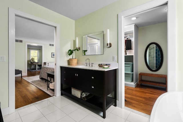 2928 Heeney Rd, Stockbridge, MI 49285 - bathroom with vanity, wood finished floors, a soaking tub, and baseboards