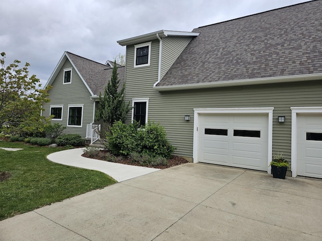 2928 Heeney Rd, Stockbridge, MI 49285 - view of front facade featuring roof with shingles, concrete driveway, a garage, and a front lawn
