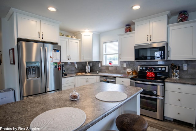 701 Knollcrest Ln, Fremont, MI 49412 - kitchen featuring stainless steel appliances, white cabinetry, decorative backsplash, and recessed lighting