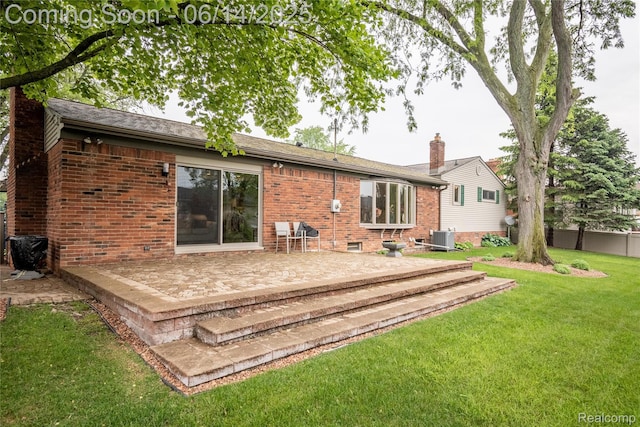 12950 Via Catherina Dr, Grand Blanc, MI 48439 - back of property with a chimney, a patio, and brick siding