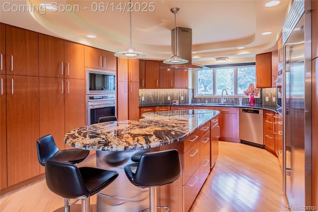 12950 Via Catherina Dr, Grand Blanc, MI 48439 - kitchen with black appliances, brown cabinets, a kitchen island, light wood-style floors, and recessed lighting