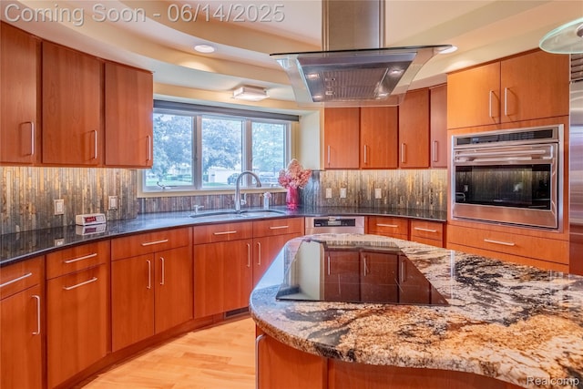 12950 Via Catherina Dr, Grand Blanc, MI 48439 - kitchen with stainless steel oven, exhaust hood, black electric stovetop, and brown cabinetry