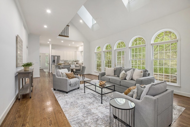 3113 Miller Rd, Ann Arbor, MI 48103 - living room featuring a skylight, high vaulted ceiling, baseboards, recessed lighting, and wood finished floors