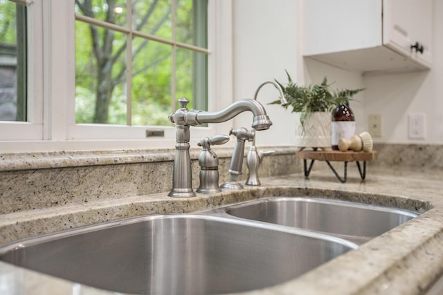 3113 Miller Rd, Ann Arbor, MI 48103 - kitchen view of a sink, white cabinets, and light stone countertops