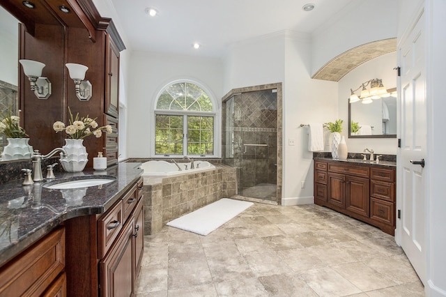 3113 Miller Rd, Ann Arbor, MI 48103 - full bathroom featuring a garden tub, two vanities, a shower stall, crown molding, and baseboards