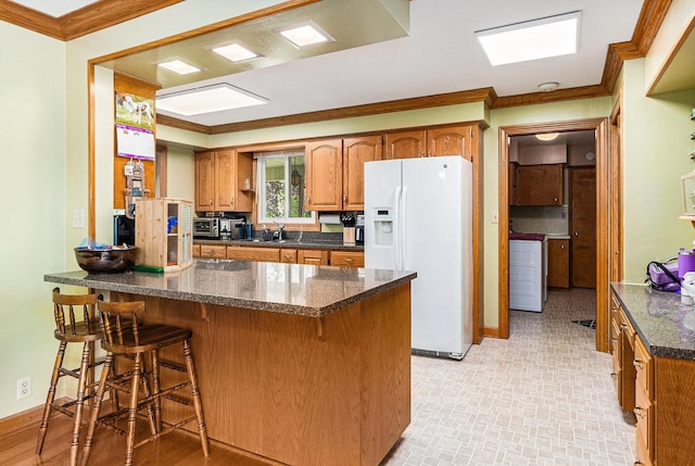 2639 Dutch Acres, Allegan, MI 49010 - kitchen with white fridge with ice dispenser, crown molding, a peninsula, brown cabinetry, and baseboards