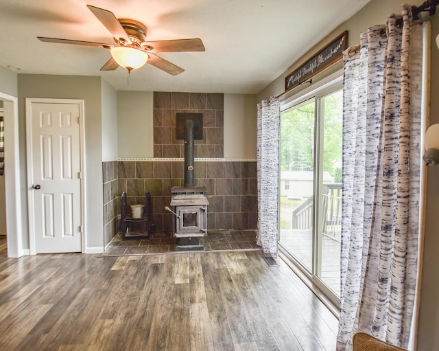 493 Swan Ln, Coldwater, MI 49036 - living area with a wood stove, wood finished floors, a ceiling fan, and tile walls