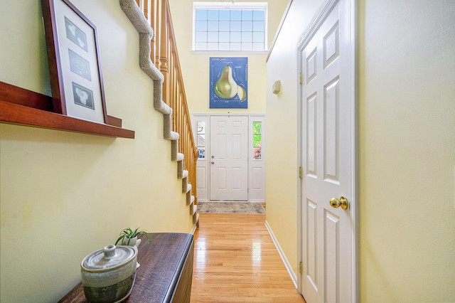 1432 Auston Ln, Chelsea, MI 48118 - entryway featuring stairs, light wood-style floors, a towering ceiling, and baseboards