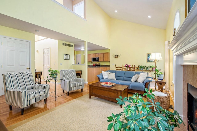 1432 Auston Ln, Chelsea, MI 48118 - living room with a towering ceiling, light wood-style flooring, and a fireplace
