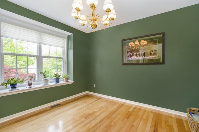 1432 Auston Ln, Chelsea, MI 48118 - empty room featuring a chandelier, baseboards, and wood finished floors