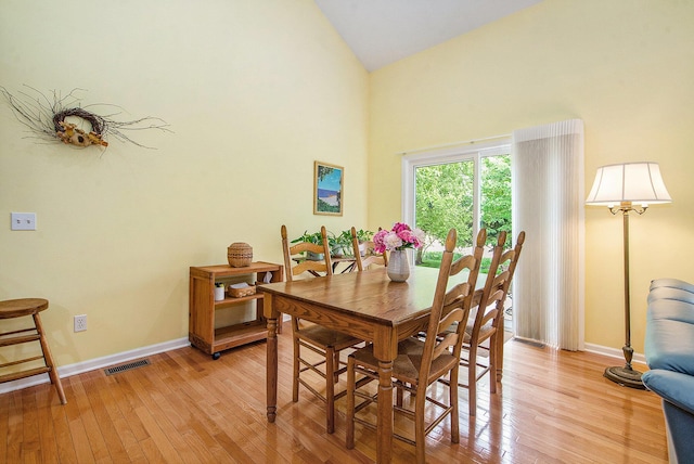 1432 Auston Ln, Chelsea, MI 48118 - dining room featuring light wood-style flooring, high vaulted ceiling, and baseboards