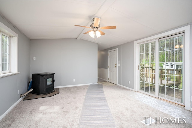 3010 E 96th St, Newaygo, MI 49337 - unfurnished living room featuring a wood stove, plenty of natural light, a ceiling fan, and carpet