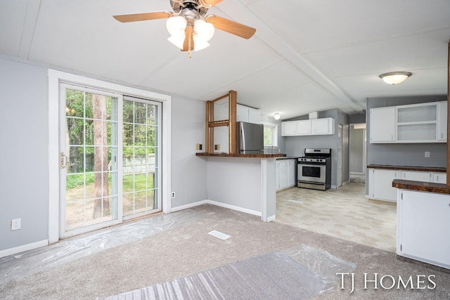 3010 E 96th St, Newaygo, MI 49337 - kitchen with appliances with stainless steel finishes, dark countertops, open shelves, white cabinetry, and healthy amount of natural light