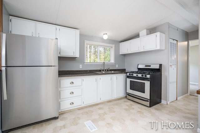 3010 E 96th St, Newaygo, MI 49337 - kitchen with stainless steel appliances, a sink, white cabinetry, dark stone countertops, and baseboards