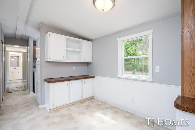 3010 E 96th St, Newaygo, MI 49337 - kitchen featuring vaulted ceiling, dark countertops, open shelves, wainscoting, and white cabinets