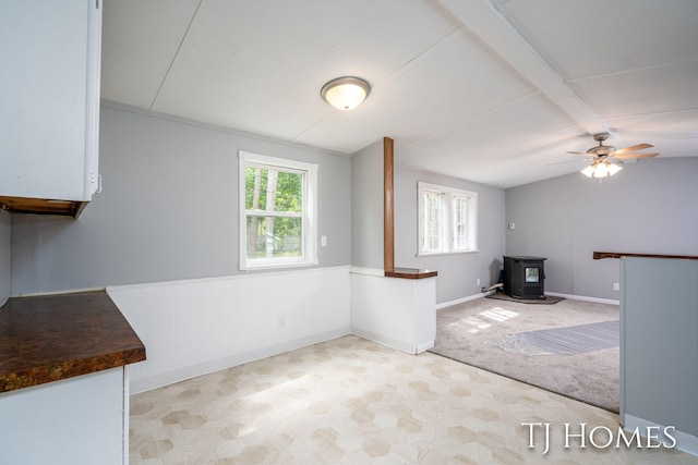 3010 E 96th St, Newaygo, MI 49337 - unfurnished living room featuring a wood stove, plenty of natural light, baseboards, and a ceiling fan