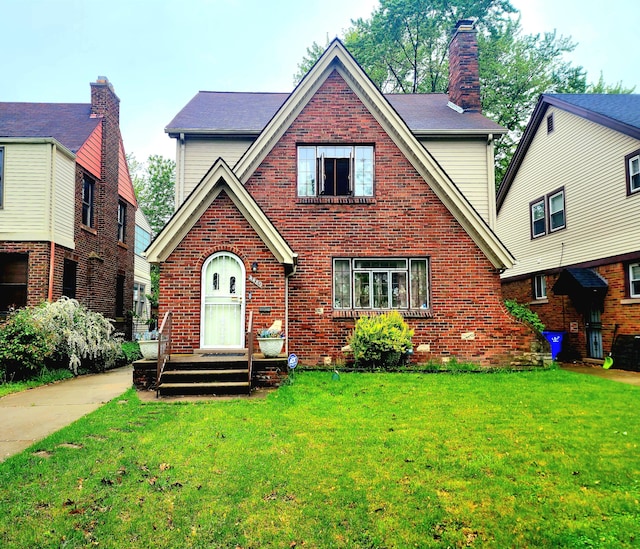 4489 Kensington Ave, Detroit, MI 48224 - view of front of property with brick siding, a front yard, and a chimney