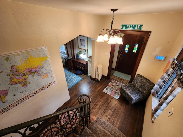 4489 Kensington Ave, Detroit, MI 48224 - entrance foyer with radiator heating unit, wood finished floors, and a chandelier