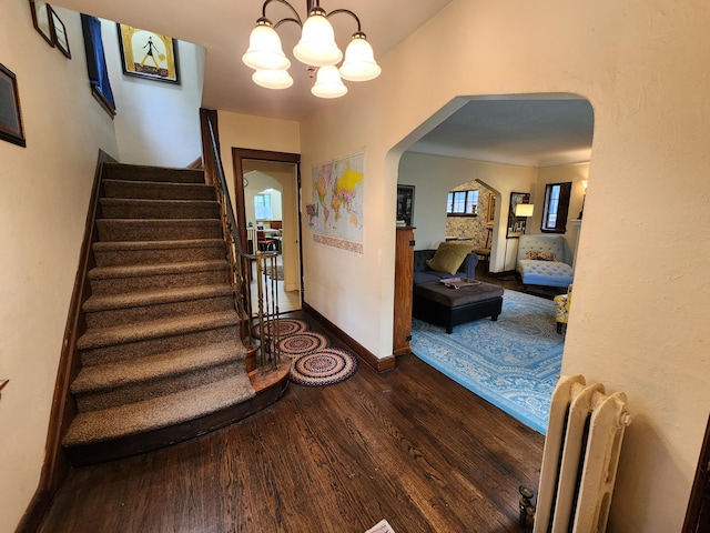 4489 Kensington Ave, Detroit, MI 48224 - foyer with dark wood-type flooring, arched walkways, a chandelier, and stairs