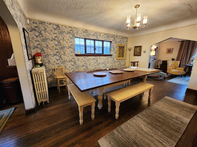 4489 Kensington Ave, Detroit, MI 48224 - dining space featuring arched walkways, a chandelier, wallpapered walls, wood finished floors, and a textured ceiling