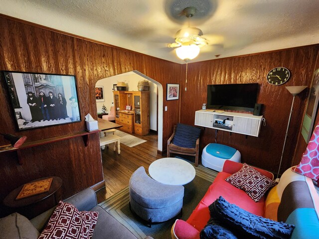 4489 Kensington Ave, Detroit, MI 48224 - living room with wood walls, wood finished floors, ceiling fan, and arched walkways