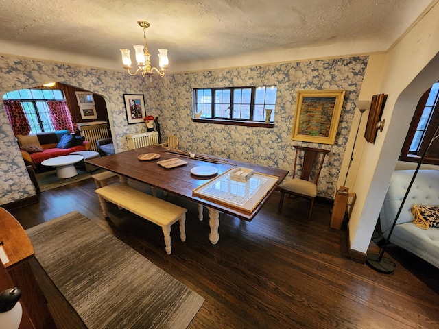 4489 Kensington Ave, Detroit, MI 48224 - dining room with wallpapered walls, a textured ceiling, arched walkways, a chandelier, and wood finished floors